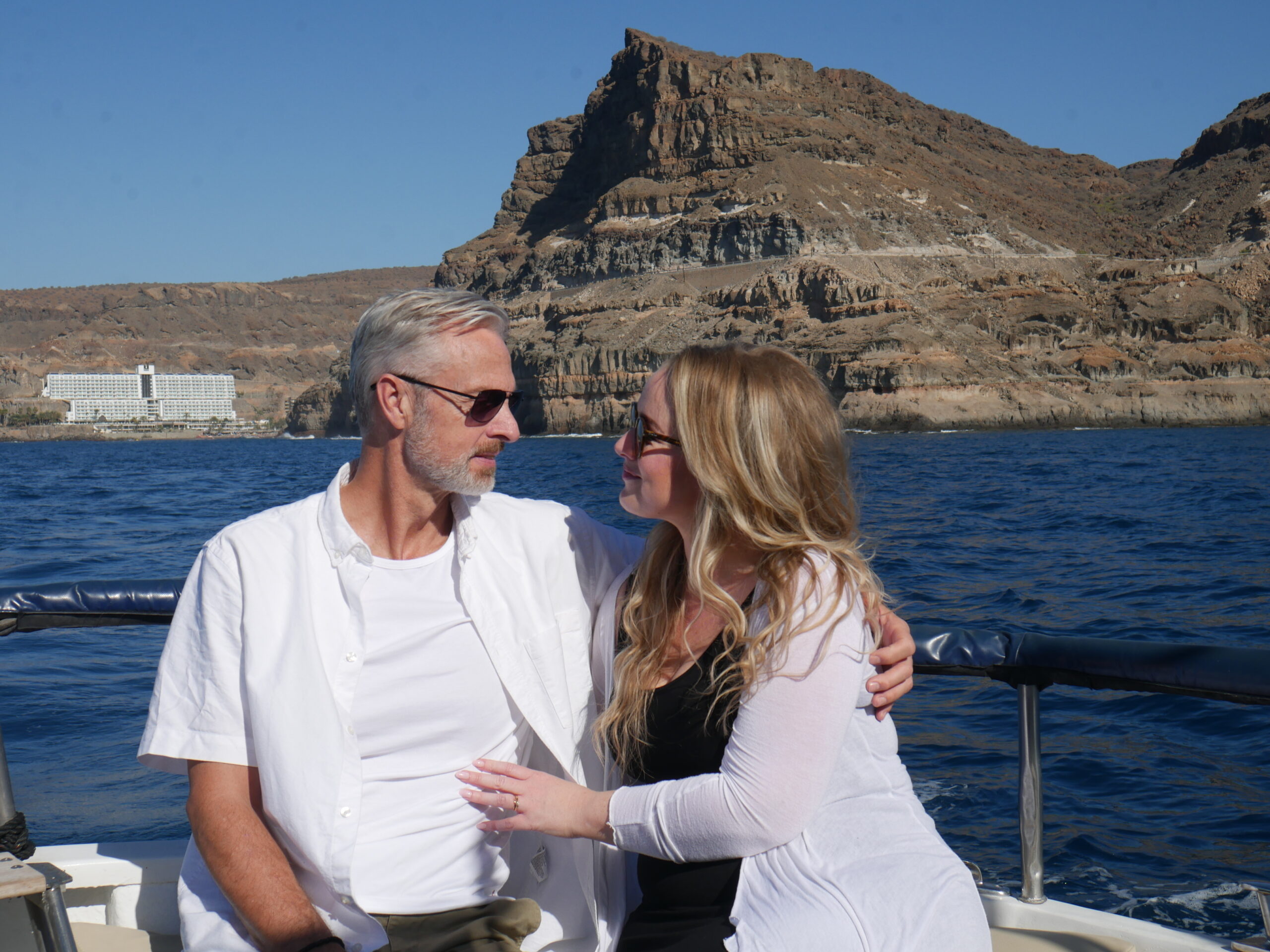 Couple Enjoying a Boat Tour with Yellow Boat Mogan in Gran Canaria Couple sitting on board Yellow Boat Mogan during a coastal boat tour, with cliffs and the Atlantic Ocean in the background near Puerto de Mogán.