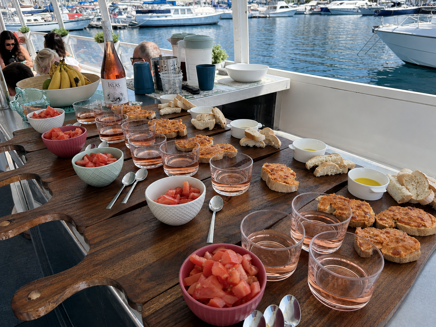 Canarian Wine & Local Food Tasting on a Boat in Puerto de Mogan Canarian wine and local food tasting served on board a boat in Puerto de Mogan, Gran Canaria, with rosé wine, local food and marina views.